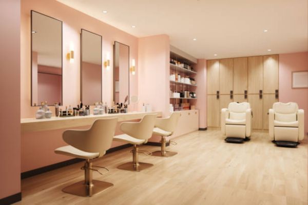 Interior of a salon adorned with soft pink walls and polished wooden floors, offering a stylish and welcoming environment.